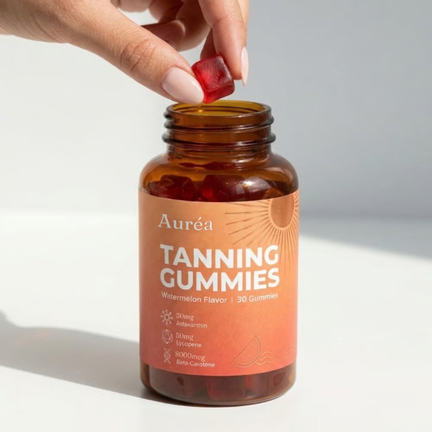 Woman holding and pointing at a jar of Auréa Tanning Gummies